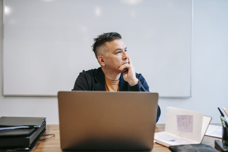 Focused businessman in home office, pondering work thoughts. Perfect for remote work and telecommuting concepts.